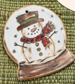 Hand-painted ceramic holiday ornament featuring a snowman design with a red scarf and a black hat, set against a white background with snow.
