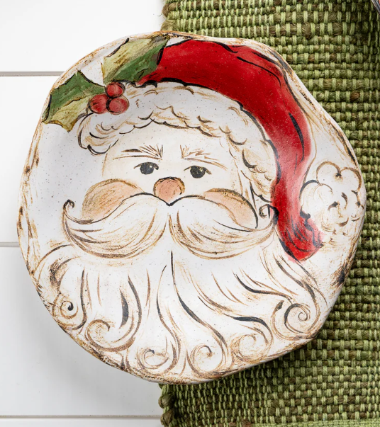 A ceramic salad plate with a Christmas-themed design featuring Santa Claus's face in the center, surrounded by a festive border.