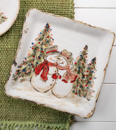 A ceramic pottery piece with a snowman and Christmas trees design, approximately 10